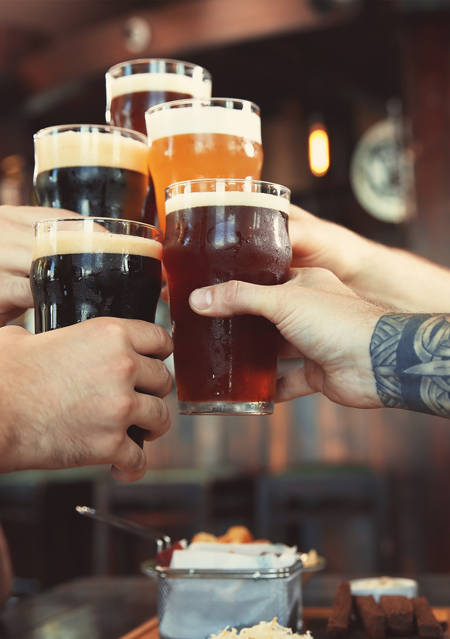 people cheersing with pints of ale