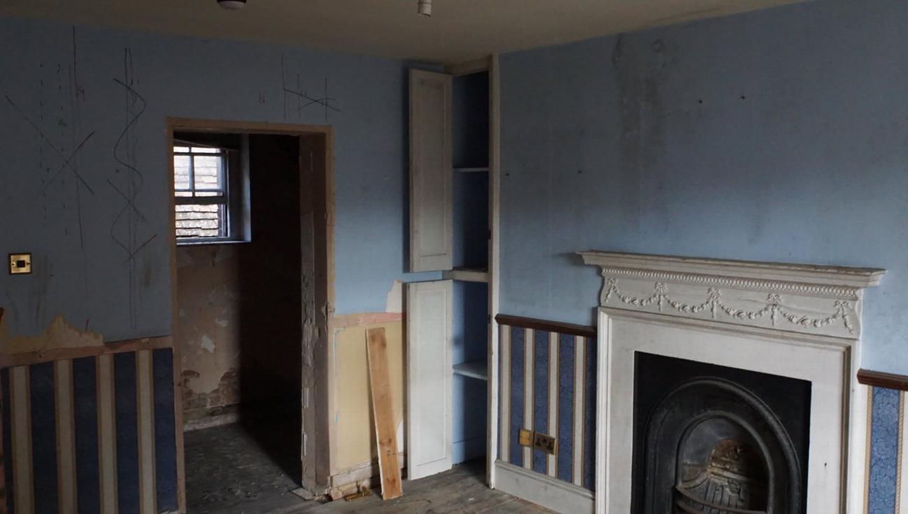 The Judge Kay room before restoration, with bare walls and stripped joinery