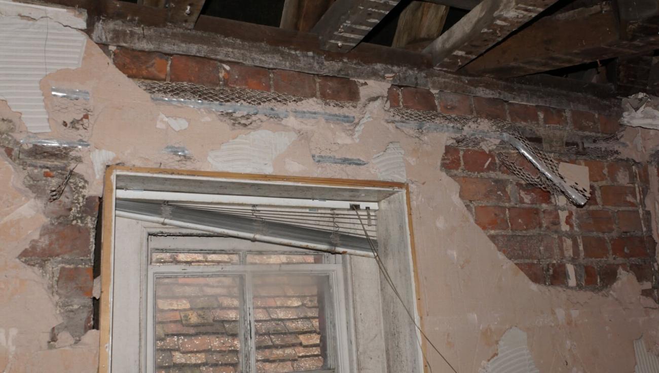 Exposed brickwork and damaged ceiling in the Judge Kay room before restoration