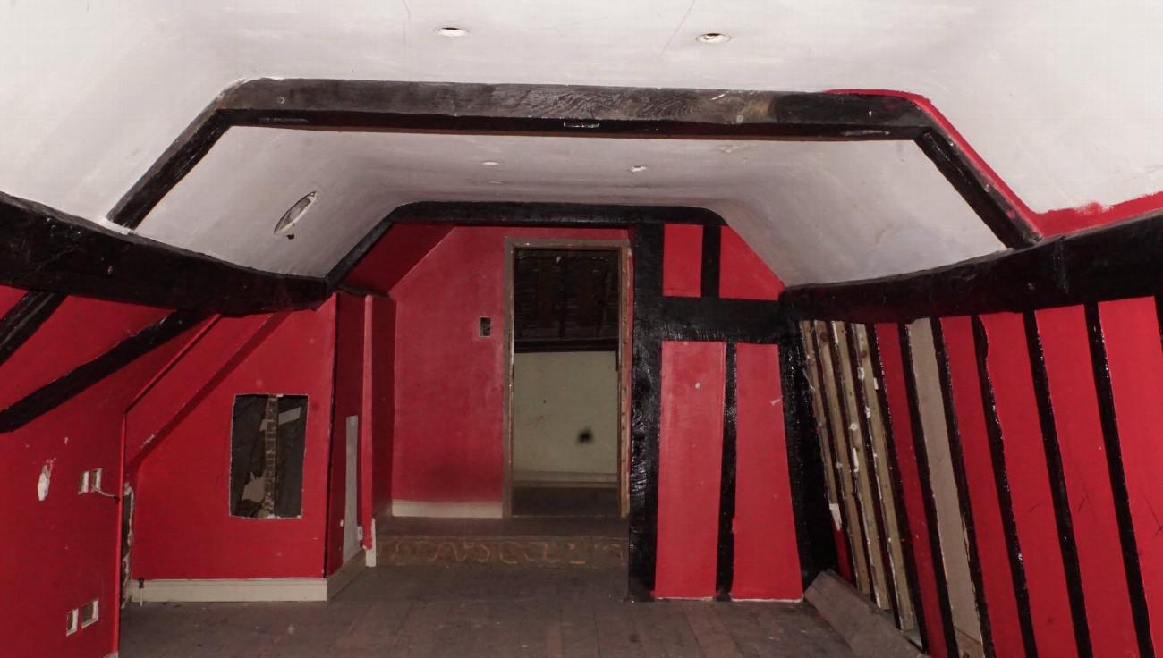 The Judge Rigby attic room at Stone Court House before restoration, painted red