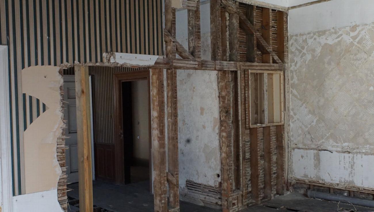 Stripped walls and open framing in the bridal suite before restoration