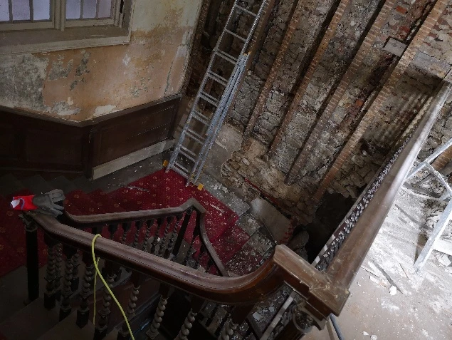Exposed beams and stripped landing at Stone Court House before restoration