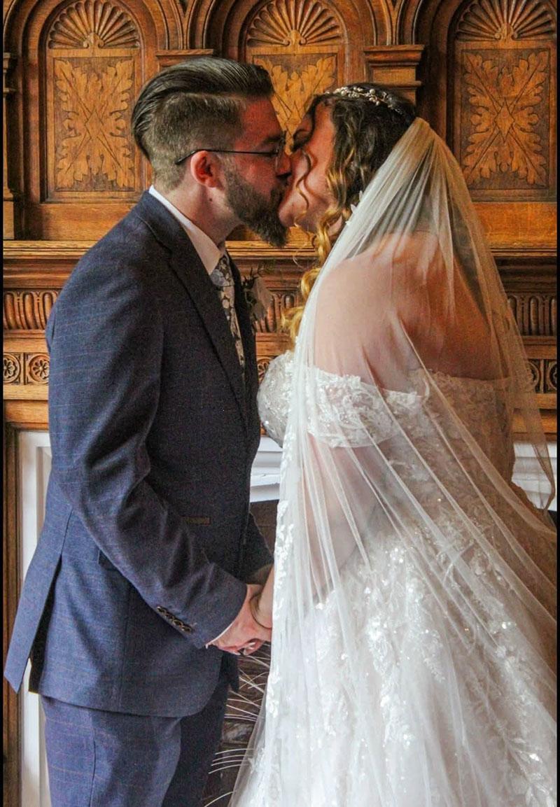 Bride and groom in front of fireplace at stone court house